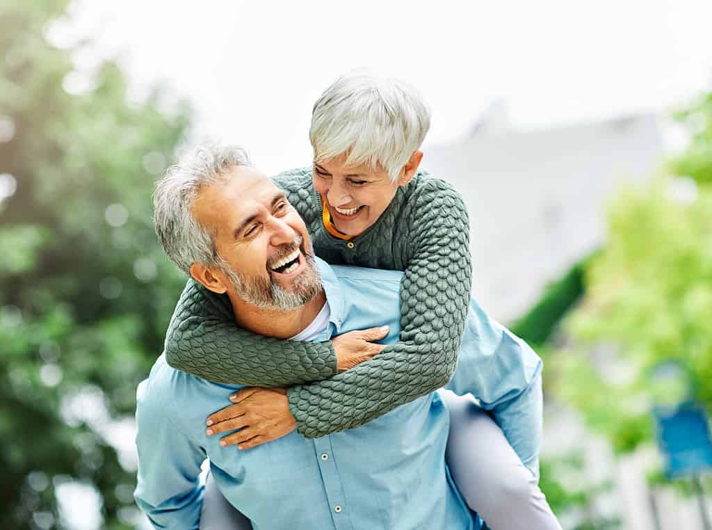 donna uomo all'aperto coppia senior stile di vita felice pensione insieme sorridente amore piggyback attivo maturo