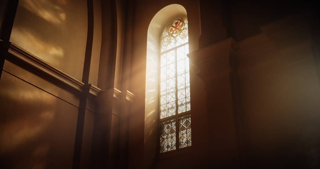 I raggi del sole filtrano attraverso le vetrate della cattedrale, benedicendo la chiesa con una luce celeste che entra nella casa del Signore.  Un ricordo dell'amore e della grazia di Dio.  Concetto cinematografico