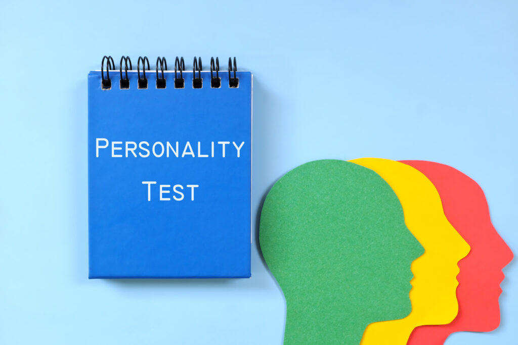 Concetto di test della personalità.  Parola scritta sul blocco note blu con la silhouette del profilo della testa umana.