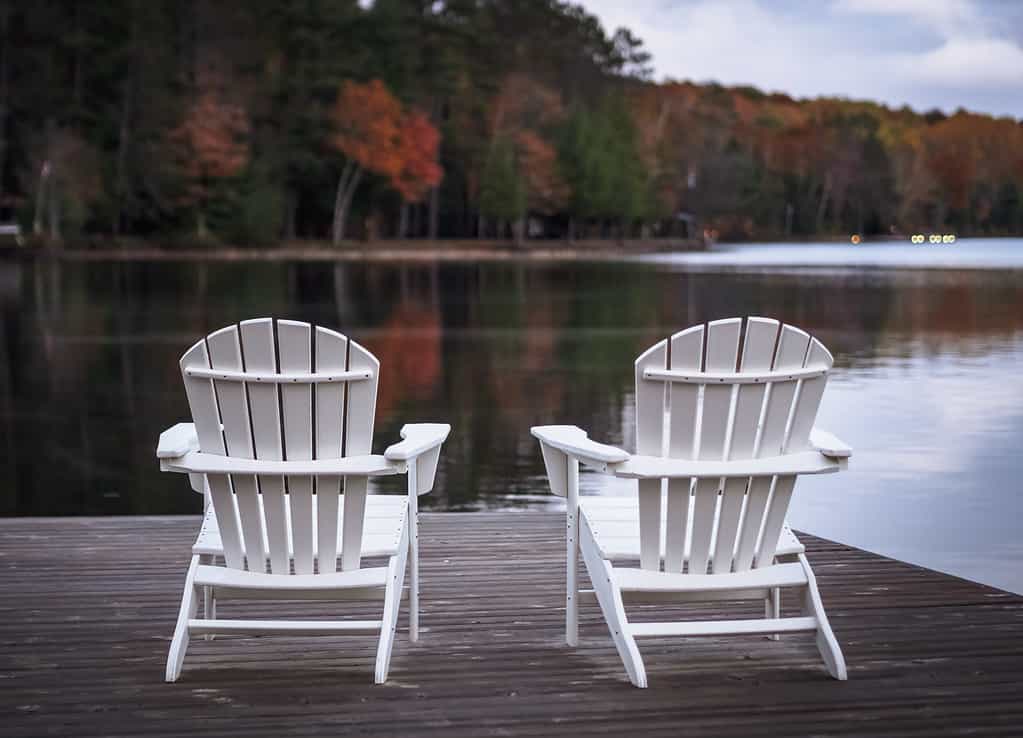 Due sedie Muskoka sul molo di fronte al lago Benoir, Harcourt, Ontario, Canada