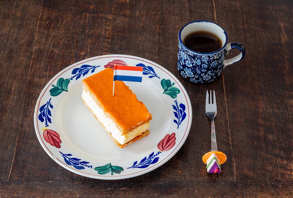 Dolce tradizionale olandese chiamato Tompouce con strato superiore arancione e bandiera olandese, tipicamente consumato durante le celebrazioni del Giorno del Re