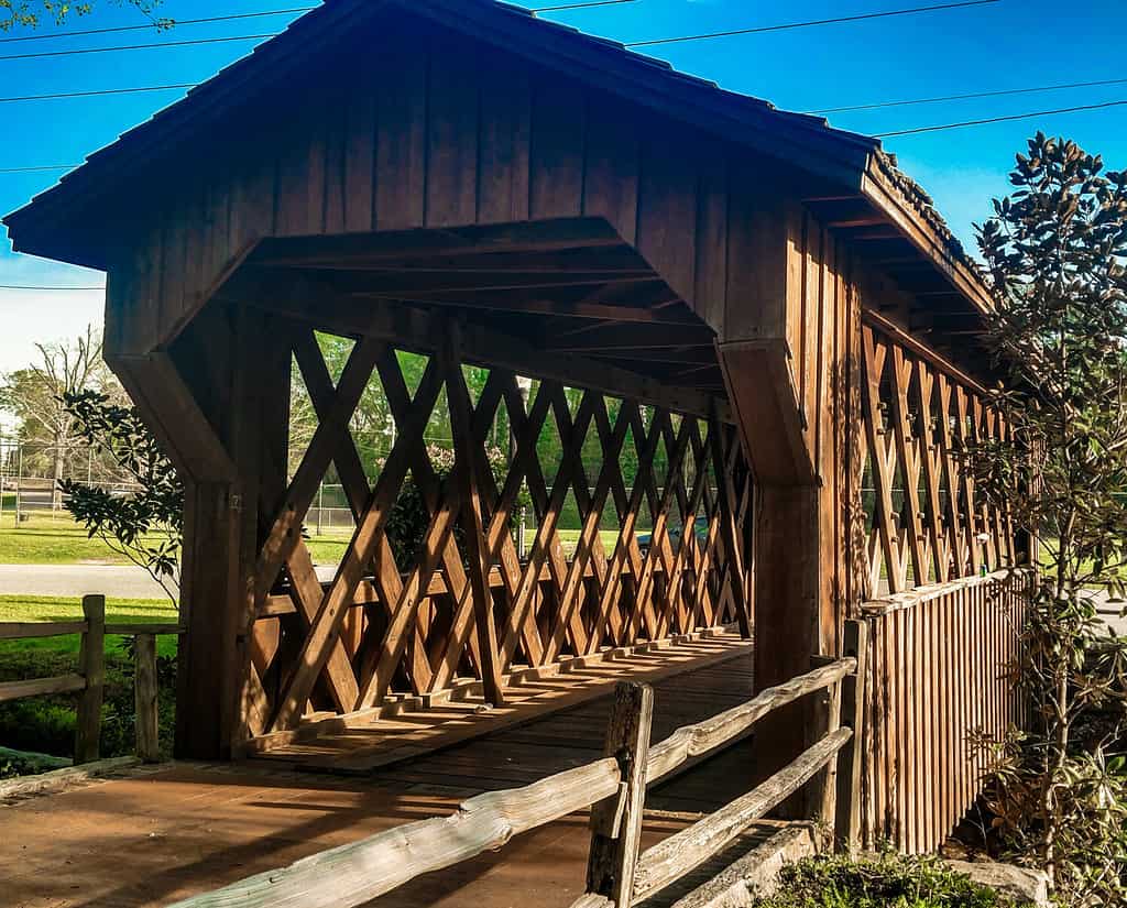 Ciò è un ponte coperto di legno nel parco municipale, Opelika, AL