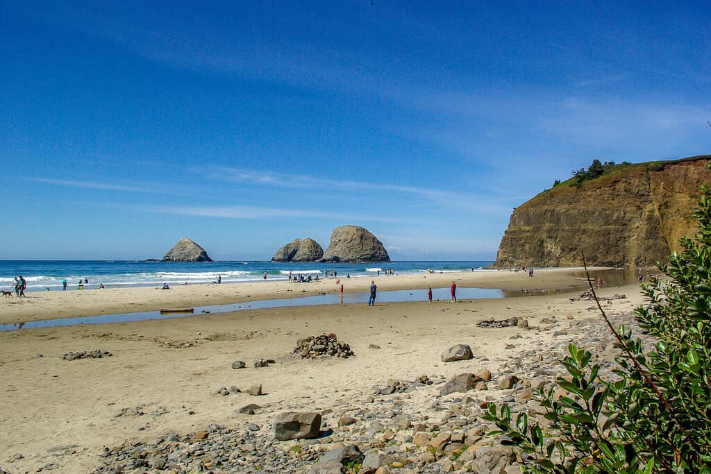 Paesaggio di turisti che giocano su Rockaway Beach sulla costa dell'Oregon vicino a Tillamook