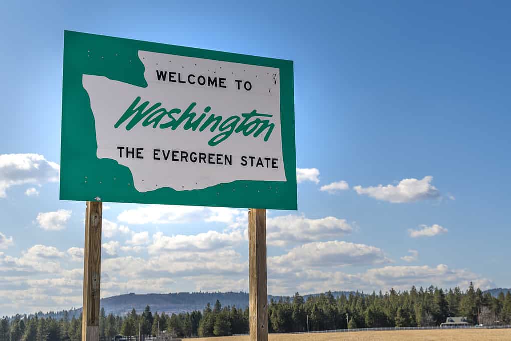 Un benvenuto lungo la strada a Washington, il cartello dello stato Evergreen nella zona rurale vicino a Spokane, Washington, USA, proveniente dallo stato dell'Idaho.