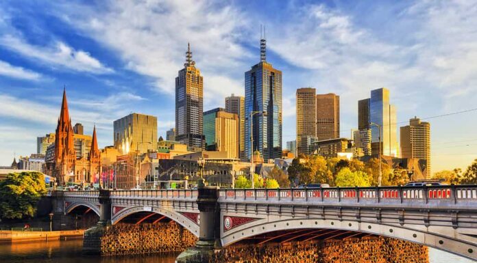 La calda luce mattutina sulle torri alte del CBD di Melbourne sopra il ponte Princes sul fiume Yarra.