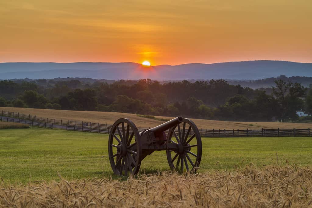 Il sole che sorge dietro l'artiglieria vicino a un campo di grano al campo di battaglia nazionale di Antietam a Sharpsburg, nel Maryland.  La battaglia di Antietam fu la più sanguinosa battaglia di un giorno nella storia americana.