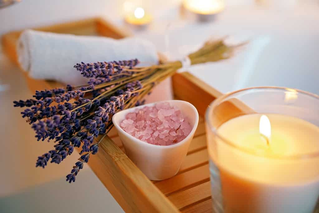 Candele, sale aromatico e lavanda sul tavolo della vasca