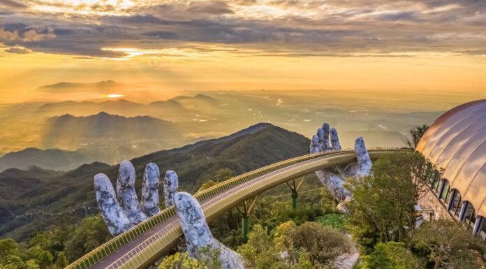 La vista aerea del Ponte d'Oro viene sollevata da due mani giganti nella località turistica sulla collina Ba Na a Da Nang, Vietnam.  La località montana di Ba Na è una delle destinazioni preferite dai turisti