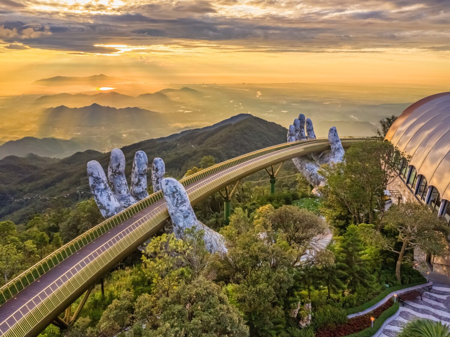 La vista aerea del Ponte d'Oro viene sollevata da due mani giganti nella località turistica sulla collina Ba Na a Da Nang, Vietnam.  La località montana di Ba Na è una delle destinazioni preferite dai turisti