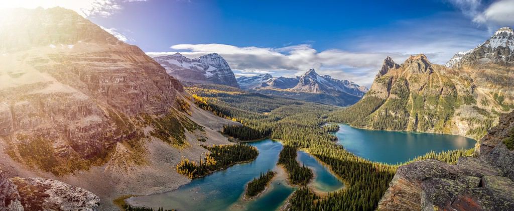 Vista panoramica del lago glaciale con le Montagne Rocciose canadesi sullo sfondo.  Giornata soleggiata autunnale.  Situato nel lago O'Hara, nel Parco nazionale Yoho, nella Columbia Britannica, in Canada.  Panorama della natura