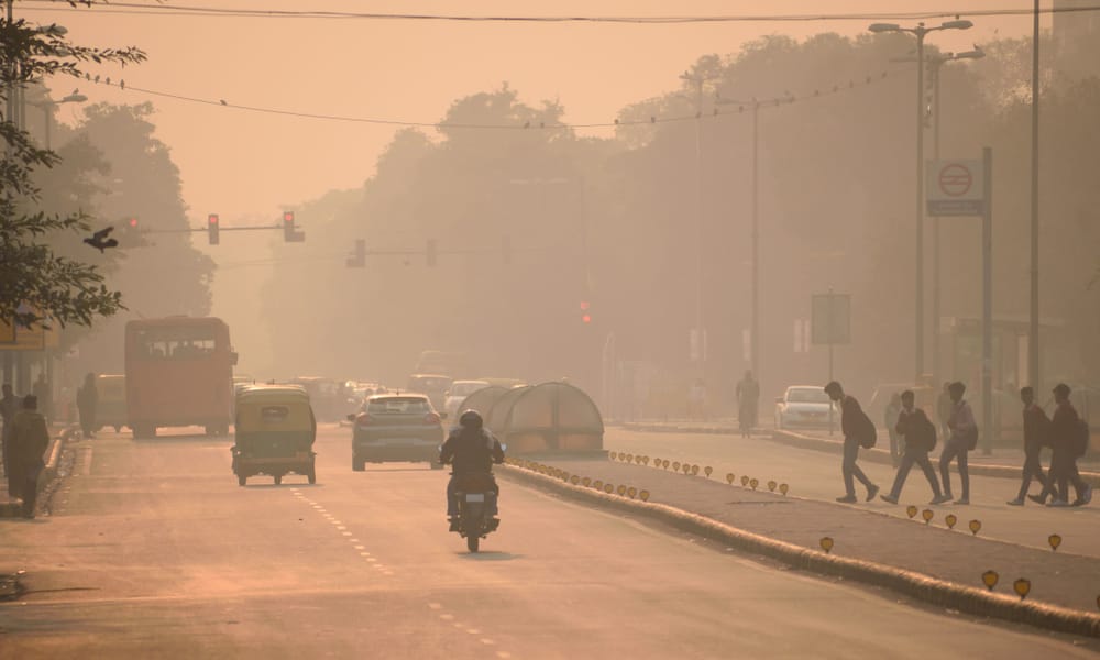 Veicoli e persone che si muovono per le strade in mezzo a un forte smog.