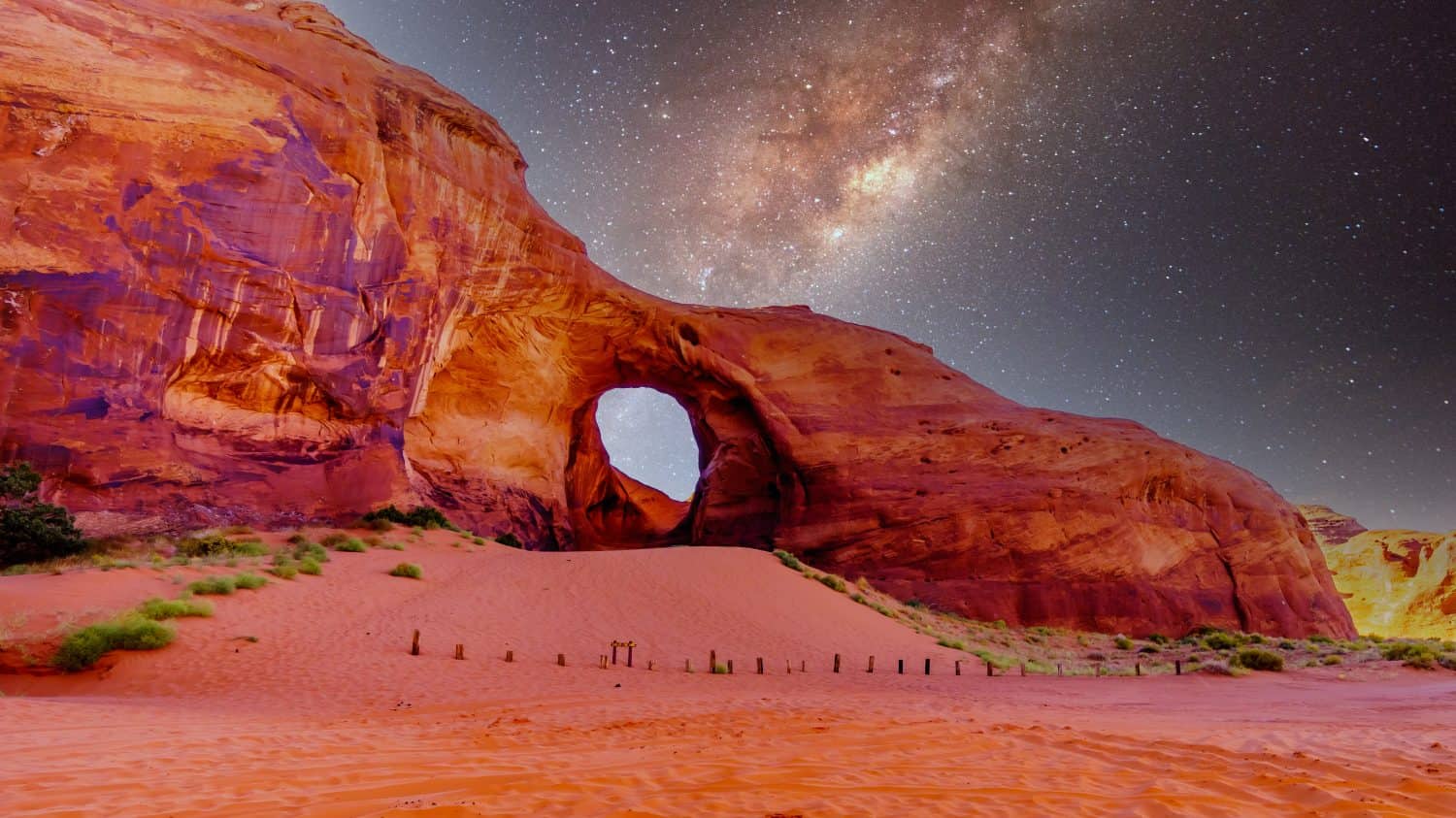 Cielo stellato dietro l'orecchio del vento, un buco in una formazione rocciosa nel parco tribale Navajo Monument Valley al confine tra Utah e Arizona, Stati Uniti