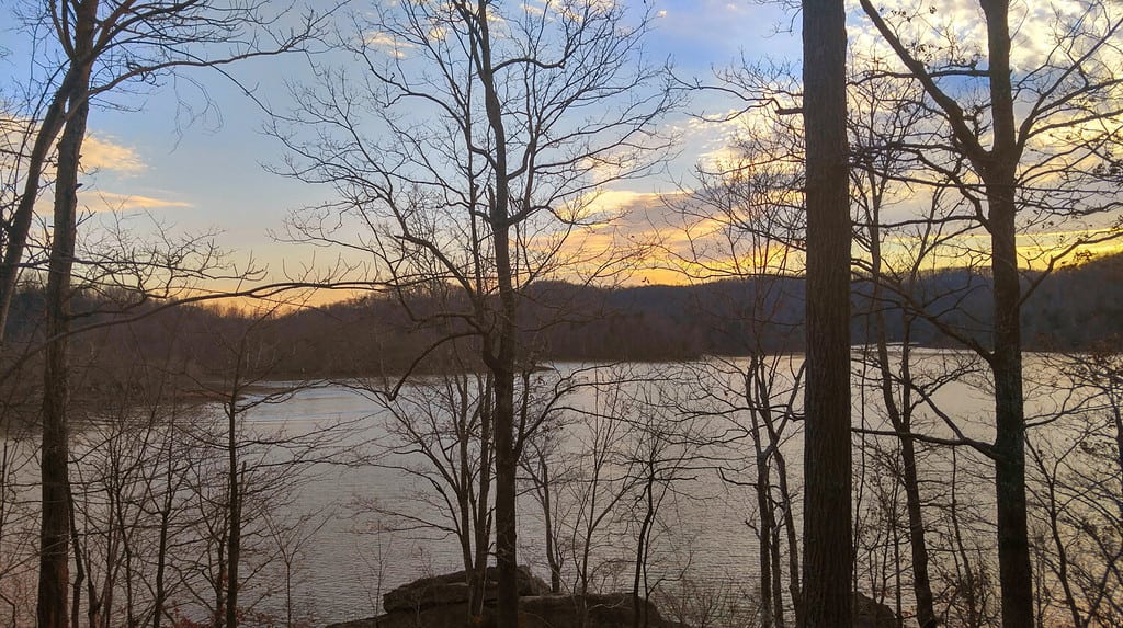 Sole che tramonta sul lago Yatesville visto tra gli alberi sul sentiero naturalistico