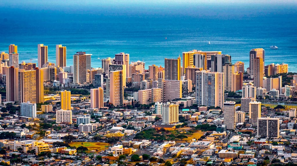 Paesaggio urbano della città di Honolulu e della spiaggia di Waikiki con oceano blu e riflesso della luce dal cielo al tramonto agli edifici dal belvedere di Ualaka'a sul monte Tantalus a Honolulu, Oahu, Hawaii USA