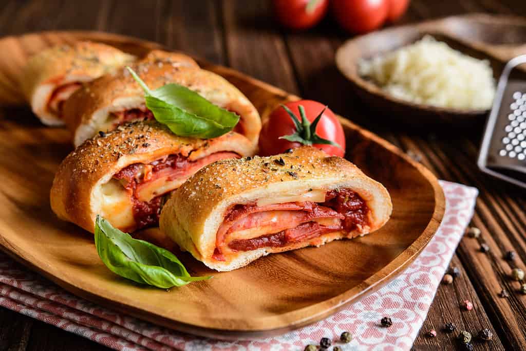 Stromboli ripieno di formaggio, salame, cipolla verde e salsa di pomodoro