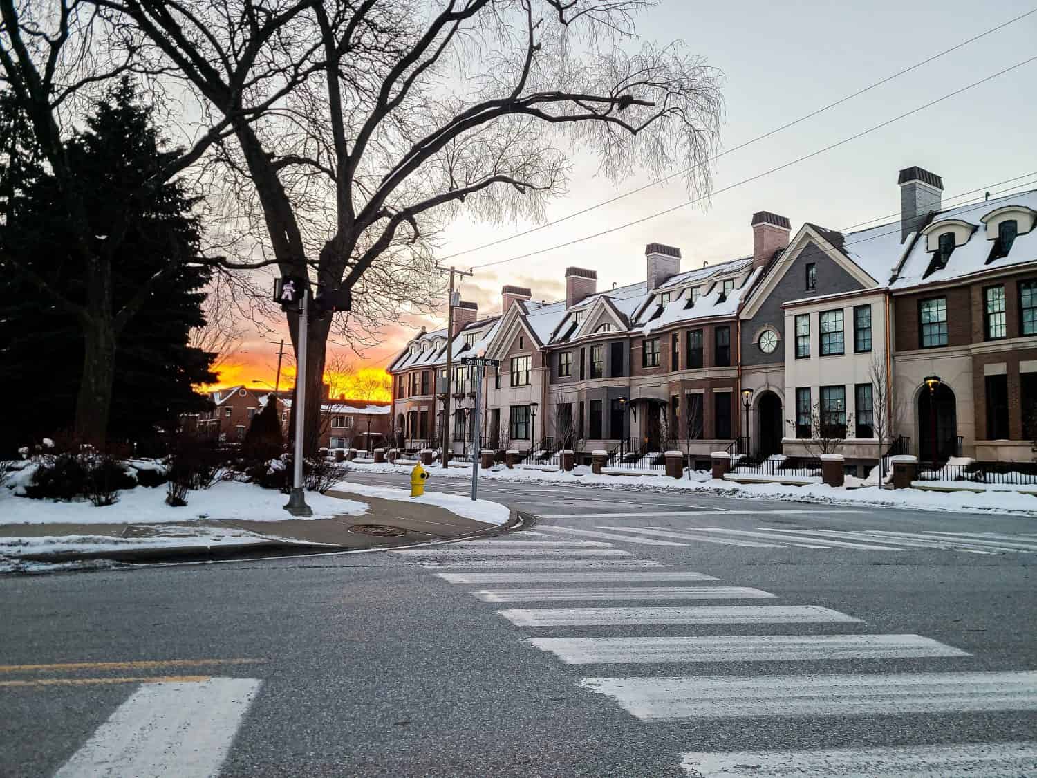 Tramonto in inverno nel centro di Birmingham, Michigan, con case a schiera in primo piano, piste di pattinaggio su ghiaccio nel Michigan