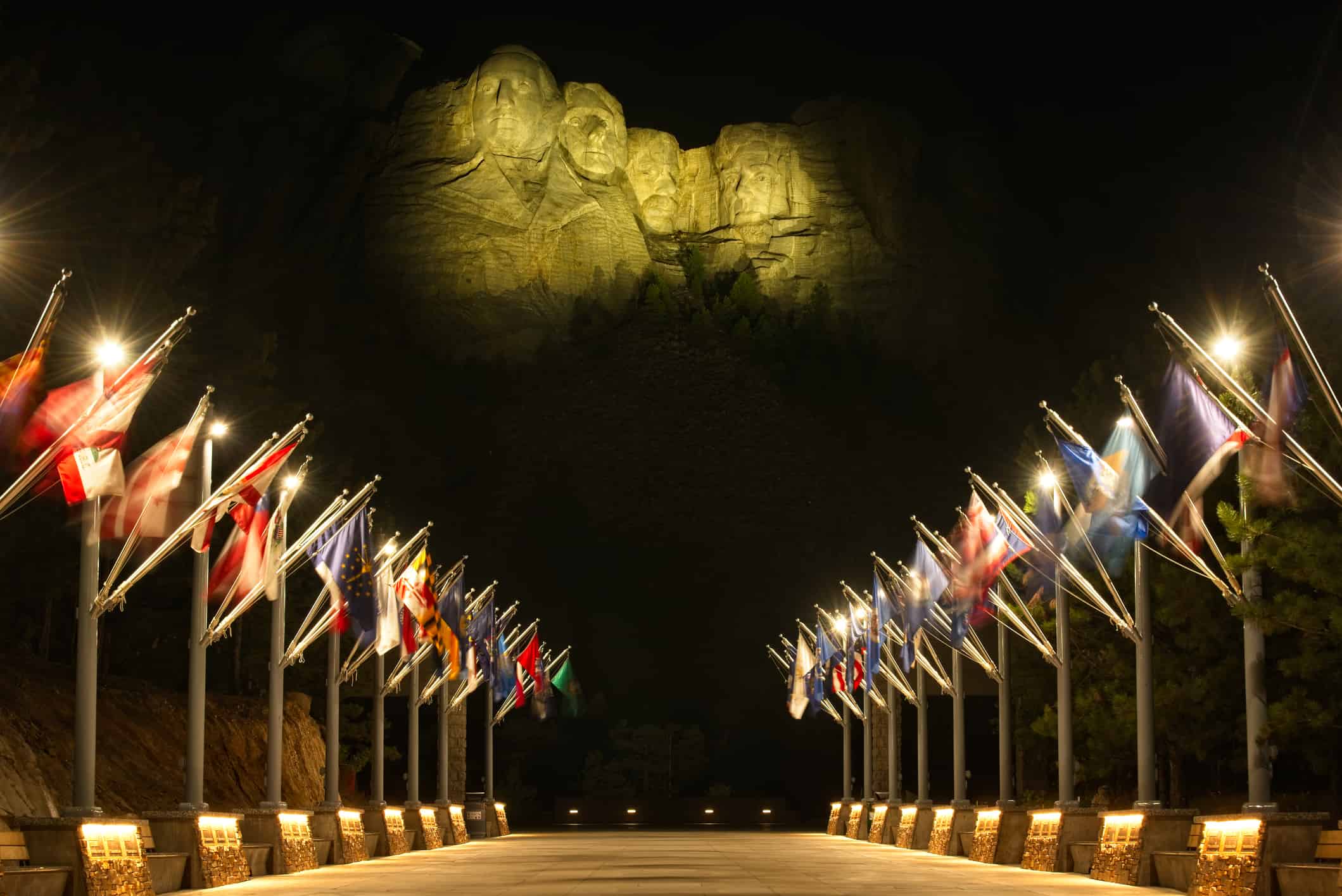 Illuminato Rushmore sopra le bandiere