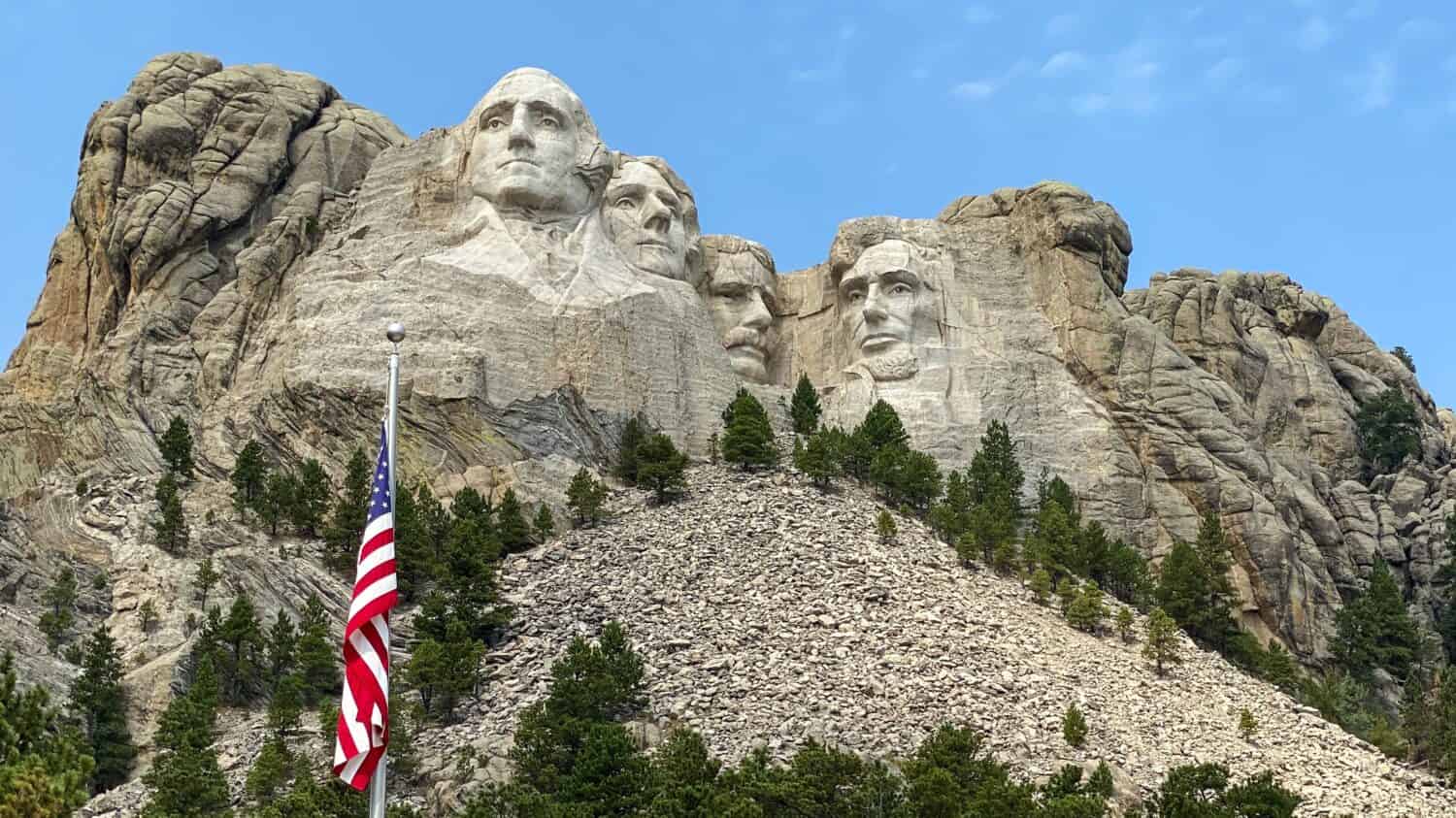 montare rushmore e bandiera americana contro un cielo blu