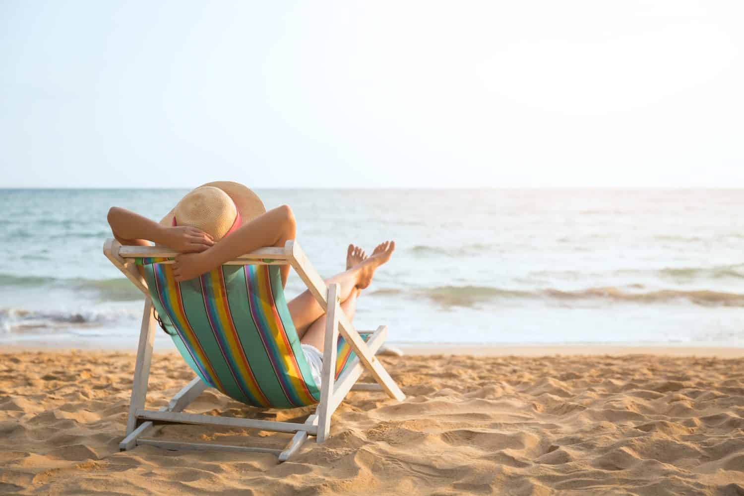 Concetto di vacanza estiva sulla spiaggia, donna asiatica con cappello rilassante e braccio sulla sedia spiaggia a Koh Mak, Trad, Thailandia