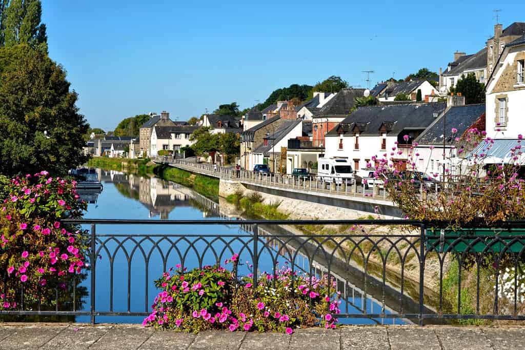 Fiume Oust visto dal ponte, parte del canale Nantes a Brest, e fiori a Josselin, un comune nel dipartimento di Morbihan in Bretagna, nel nord-ovest della Francia