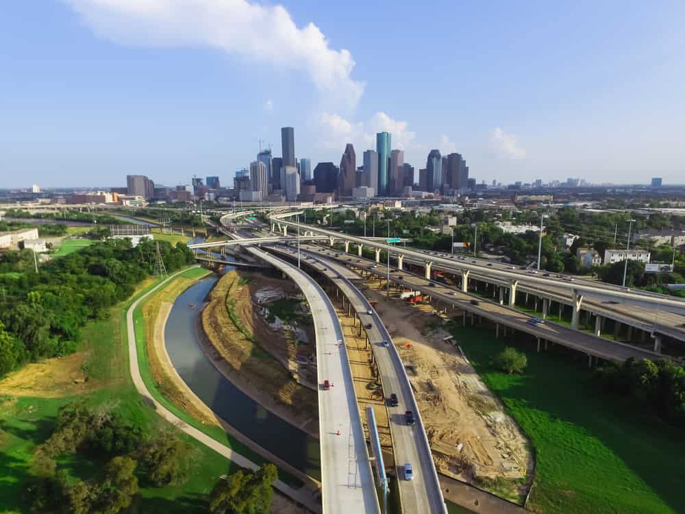 Vista aerea del centro e dell'autostrada interstatale I45 con massiccia intersezione, interscambio di pile, cavalcavia dello svincolo stradale e costruzione di strade sopraelevate al tramonto dal lato nord-ovest di Houston, Texas, Stati Uniti