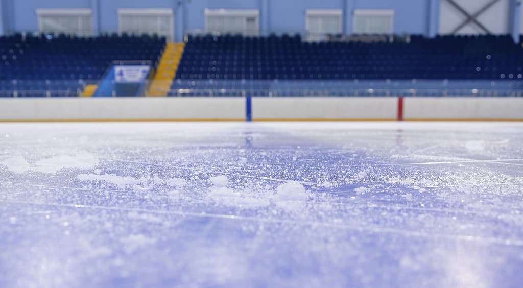 Tribune vuote dell'arena del ghiaccio e ghiaccio pulito tagliato dai pattini.