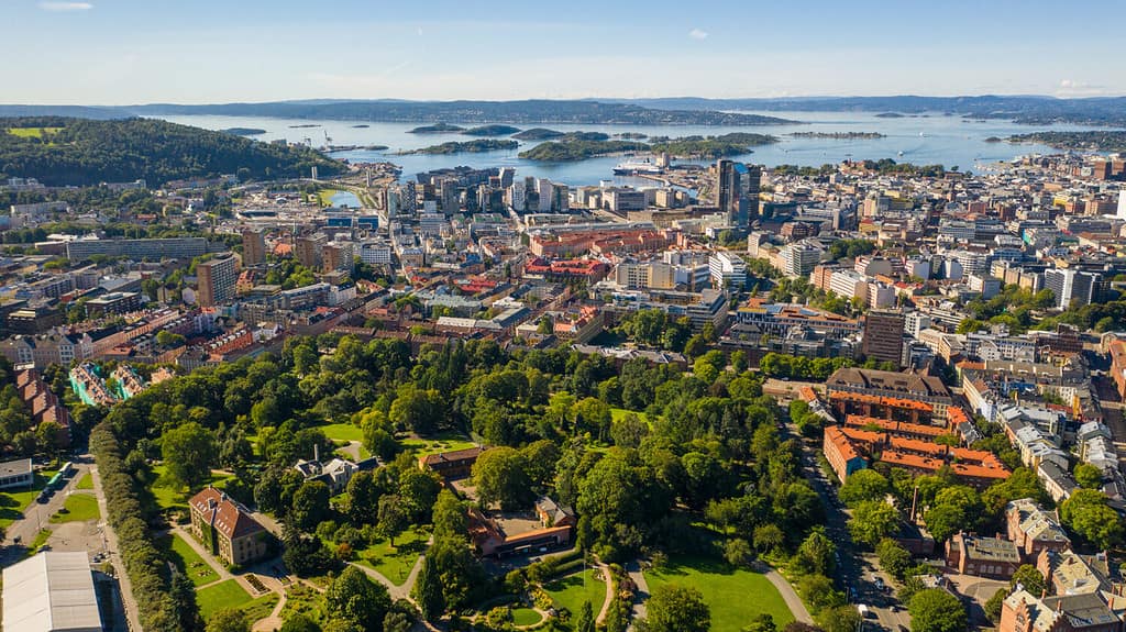 Oslo, Norvegia. Bellissima foto panoramica aerea scattata da un drone in volo per il centro di Oslo. Sullo sfondo il mare, le montagne e il cielo azzurro in una soleggiata giornata estiva. (Serie)
