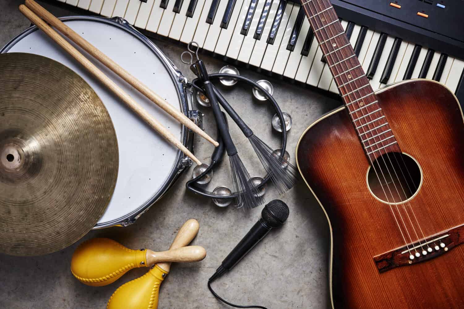un gruppo di strumenti musicali tra cui chitarra, tamburo, tastiera, tamburello.
