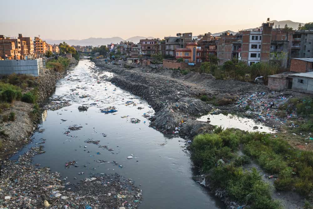 Il fiume contaminato attraversa la città.  i rifiuti vengono scartati sulla riva del fiume.  mancanza di servizi di raccolta rifiuti.  Katmandu, Nepal, Asia