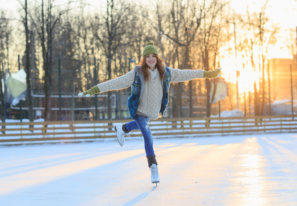 Bella ragazza che si diverte a Winter Park, in equilibrio mentre pattina sulla pista di pattinaggio.  Godersi la natura, l'inverno