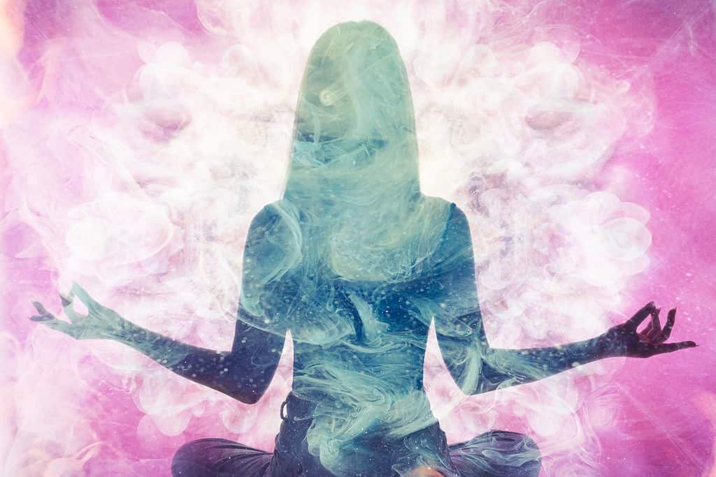 Pratica spirituale.  Equilibrio dell'armonia.  Silhouette di donna meditante in doppia esposizione di fumo etereo rosa.