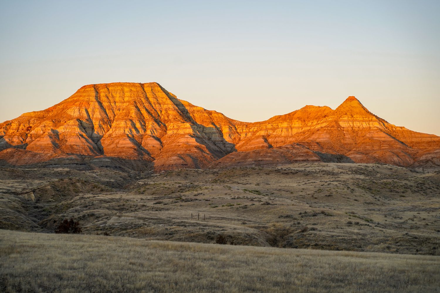 Alpenglow sulle scogliere della montagna dei calanchi nel Montana orientale durante l'alba, vicino a Miles City, MT