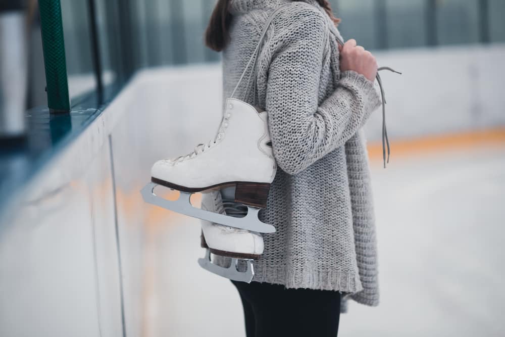 Donna alla pista di pattinaggio sul ghiaccio con i pattini.
