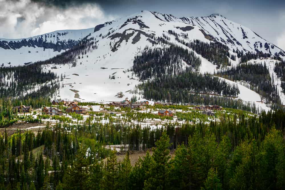 Stazione sciistica Moonlight Basin Montana, situata tra alberi di pino e montagne innevate nella catena Madison delle Montagne Rocciose di Big Sky Montana, USA