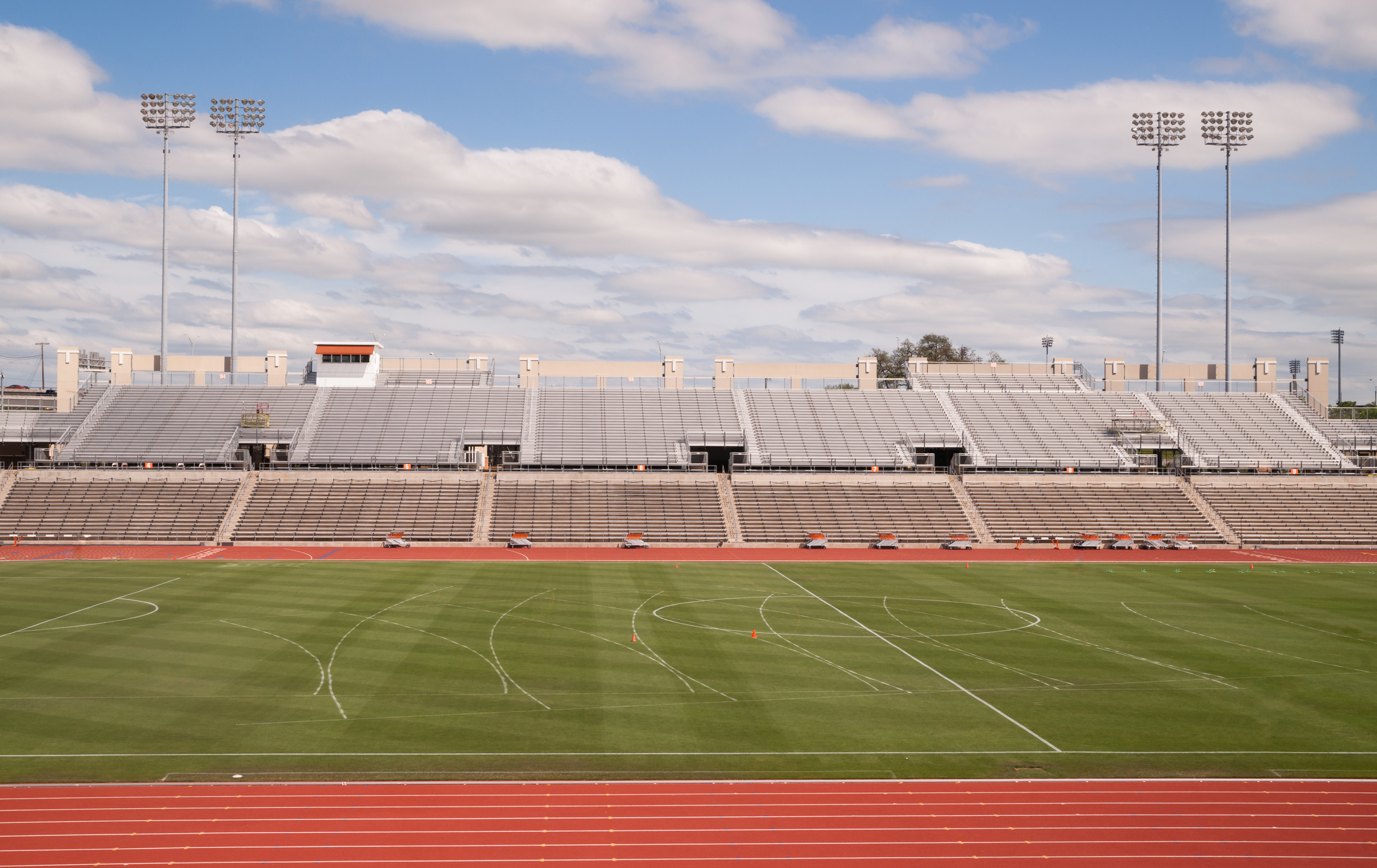 Stadio di pista a livello universitario con nuvole gonfie, cielo blu