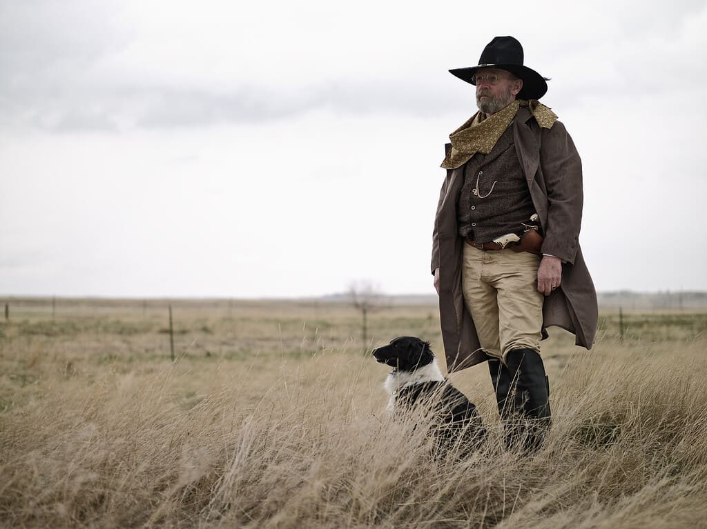 Cowboy dall'aspetto antiquato con il cane