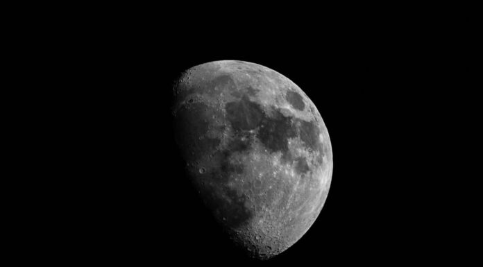 Luna ravvicinata in fase gibbosa crescente.  Superficie lunare, crateri e cielo notturno.  Isolato su sfondo nero e spazio di copia.