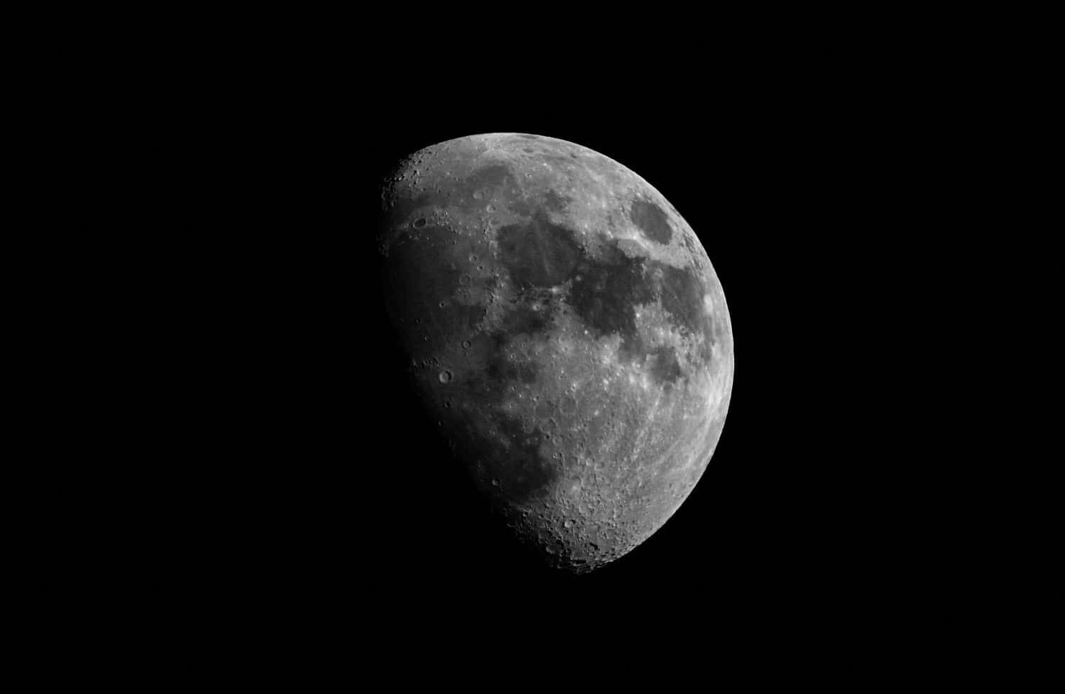 Luna ravvicinata in fase gibbosa crescente.  Superficie lunare, crateri e cielo notturno.  Isolato su sfondo nero e spazio di copia.