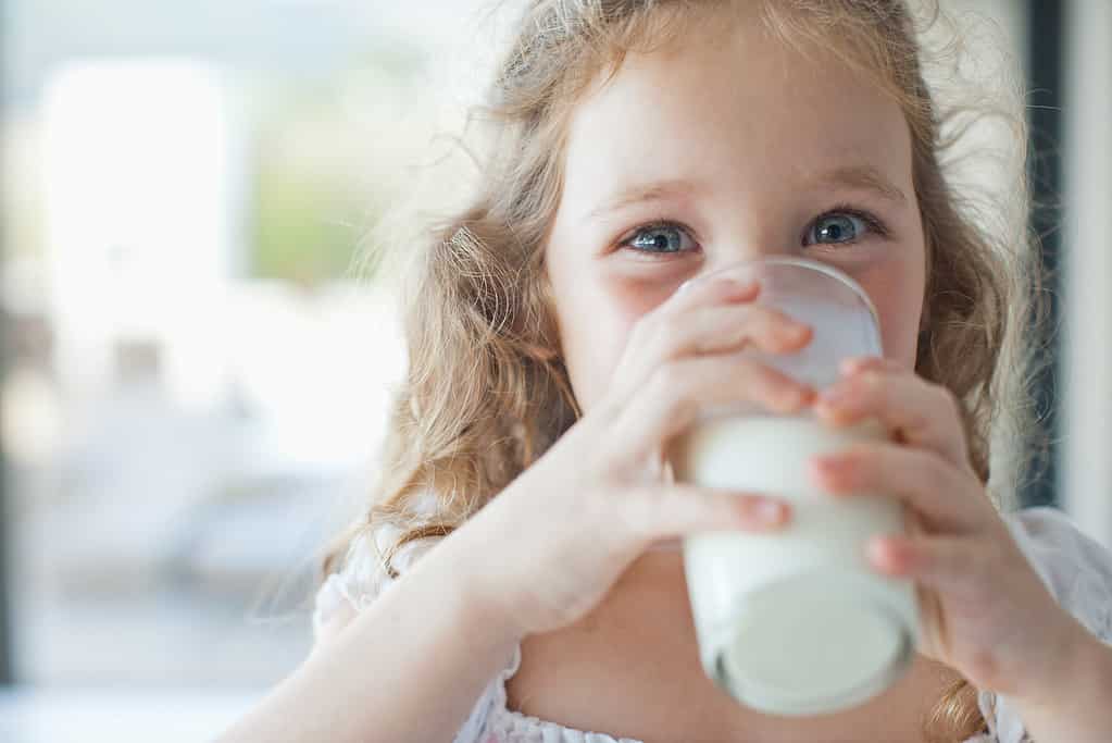 Ragazza che beve bicchiere di latte