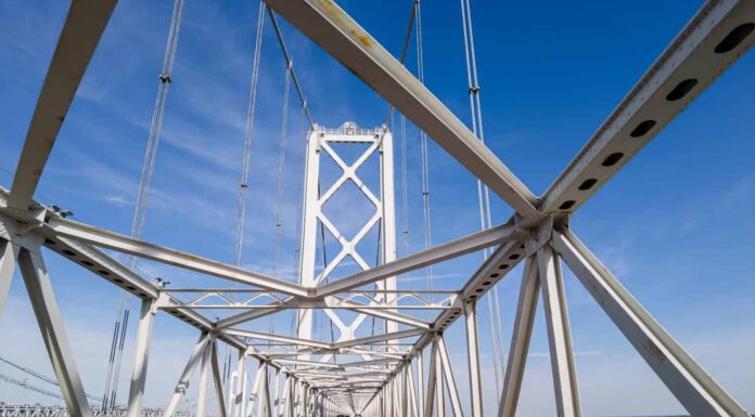 Immagine che mostra l'attraversamento del famoso ponte di Chesapeake Bay (William Preston Lane Jr. Memorial Bridge) sotto le travi di sospensione di piloni in stile traliccio metallico.  Si vedono le torri sull'altro lato.