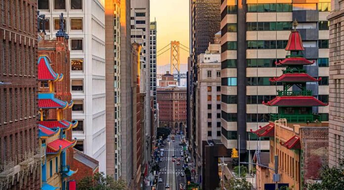 Famosa vista di California Street vicino a China Town e al quartiere finanziario, con le torri della pagoda cinese e il Bay Bridge al tramonto a San Francisco