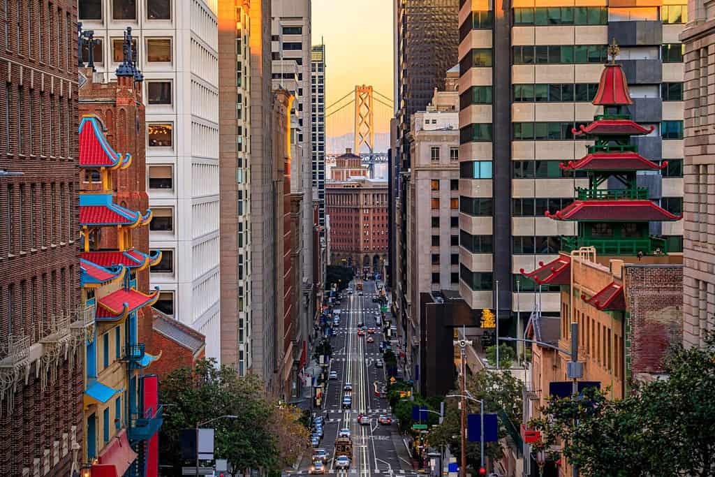 Famosa vista di California Street vicino a China Town e al quartiere finanziario, con le torri della pagoda cinese e il Bay Bridge al tramonto a San Francisco