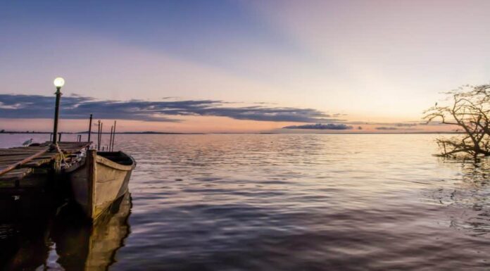 Prende il nome dalla regina Vittoria, il Lago Vittoria è il più grande lago tropicale d'acqua dolce del mondo.  Scattata all'alba, questa foto si affaccia sul lago con le isole in lontananza e una barca.