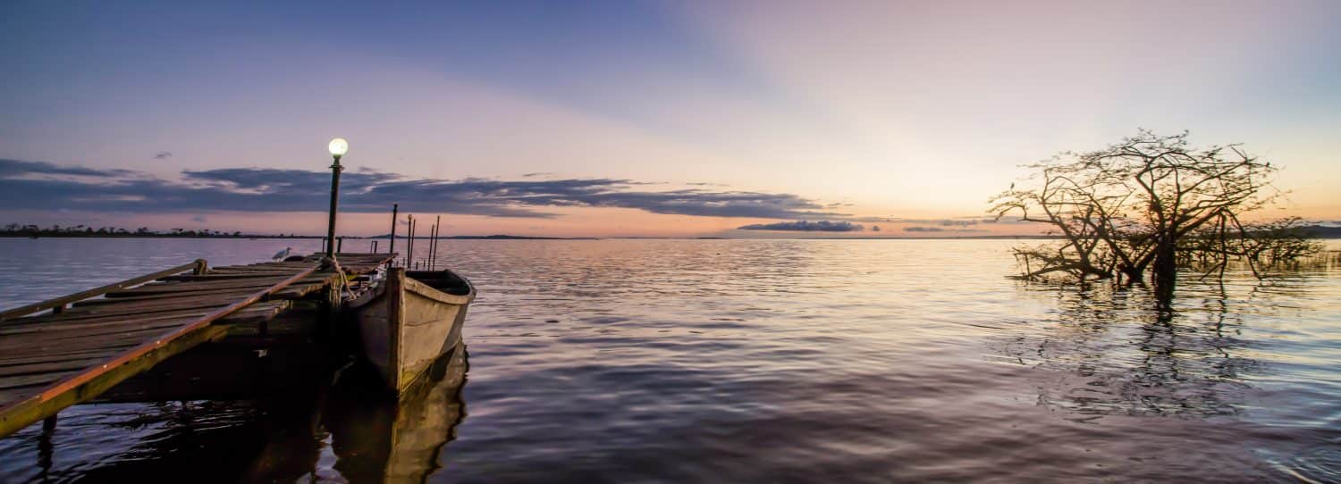 Prende il nome dalla regina Vittoria, il Lago Vittoria è il più grande lago tropicale d'acqua dolce del mondo.  Scattata all'alba, questa foto si affaccia sul lago con le isole in lontananza e una barca.