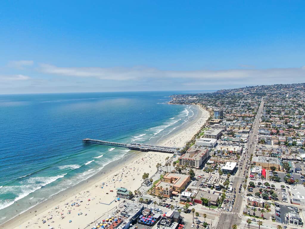 Veduta aerea di persone in spiaggia con il molo durante la giornata blu, Pacific Beach, San Diego