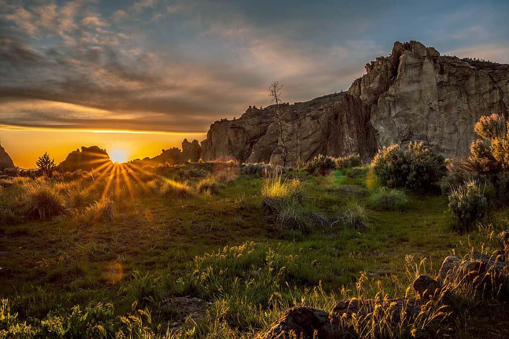 Sole che tramonta su un paesaggio collinare e montuoso allo Smith Rock State Park a Redmond, Oregon, Stati Uniti.