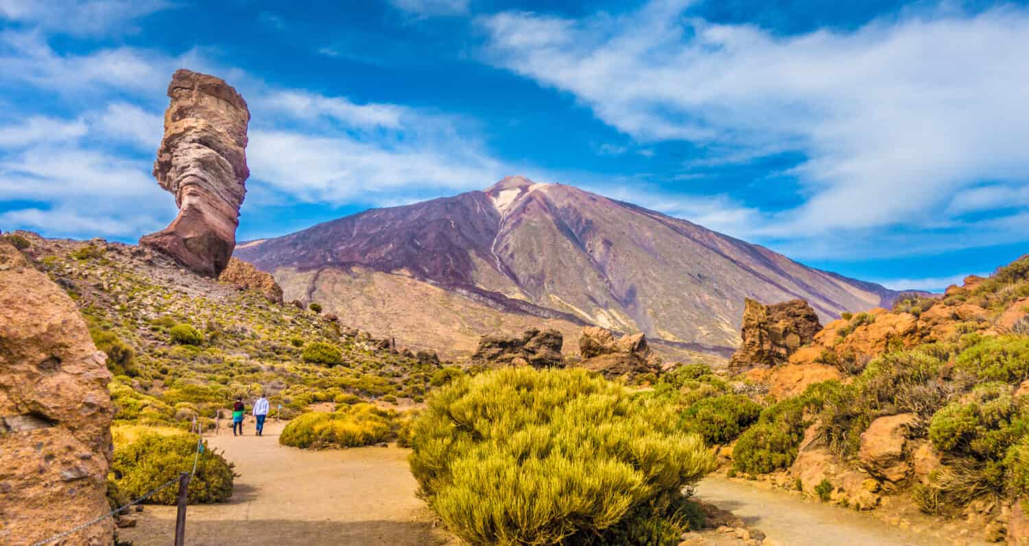 Vista panoramica dell'esclusiva formazione rocciosa Roque Cinchado con la famosa cima del vulcano di montagna Pico del Teide sullo sfondo in una giornata di sole, Parco Nazionale del Teide, Tenerife, Isole Canarie, Spagna