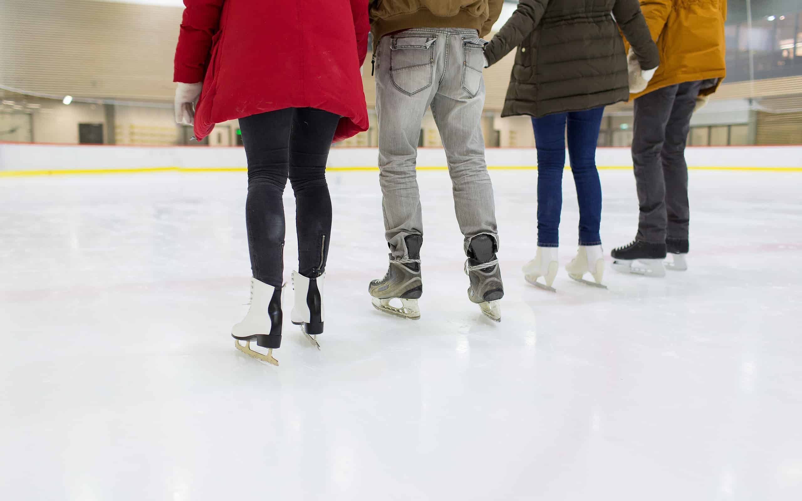 primo piano di amici felici che pattinano sulla pista di pattinaggio