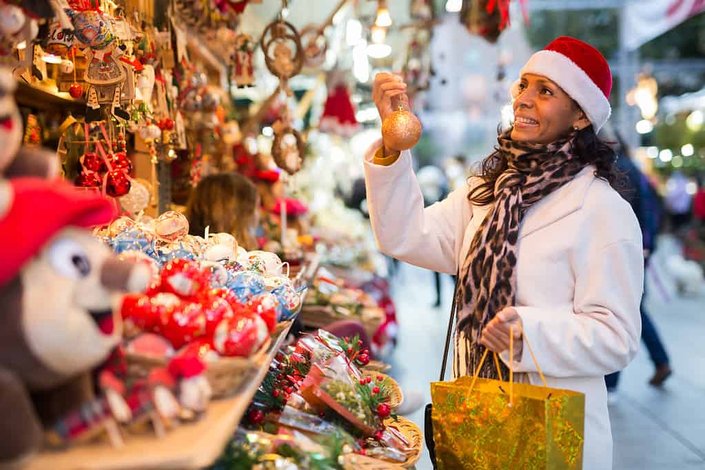 Donna positiva che seleziona i regali alla fiera di Natale