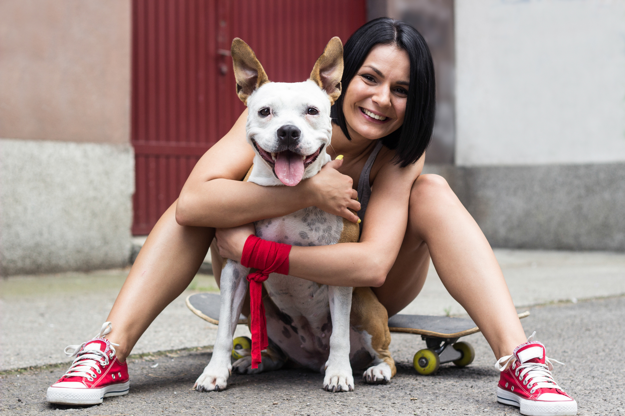 Giovane donna che abbraccia il suo cane e ride